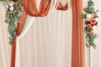 10 a bold fall wedding backdrop with white and rust-colored drapes, matching blooms and greenery and pillar and tall and thin candles