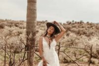 10 a bold western wedding look with a lace A-line wedding dress with a plunging neckline, a brown hat, brown cowgirl boots with patterns and statement accessories