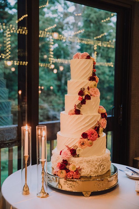 a white textural wedding cake decorated with bold flower spirals is a very chic and cool idea for a summer or fall wedding