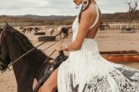 12 a fabulous western bridal look with a lace applique halter neckline wedding dress, with an open back and long fringe plus black and white boots and statement jewelry