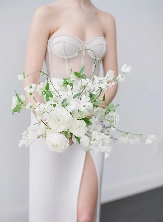 a gorgeous all-white wedding bouquet with blooming branches and greenery is a chic idea for a spring or summer bride