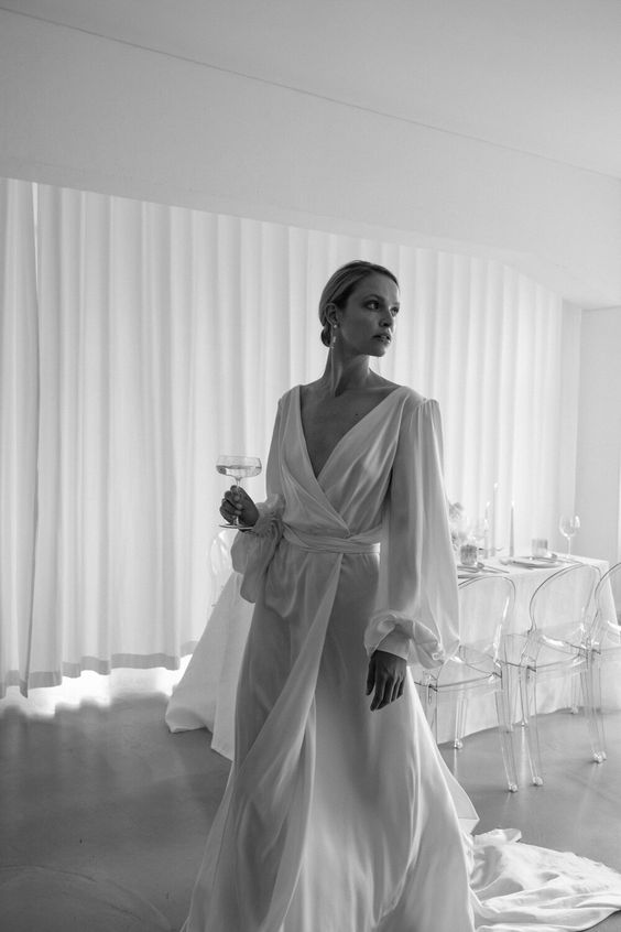 a minimal and very exquisite A line wedding dress with a draped bodice and skirt, puff sleeves and a V neckline