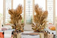 12 a western wedding ceremony space with fronds and dried grasses plus bold blooms, rugs and gilded and wooden lanterns