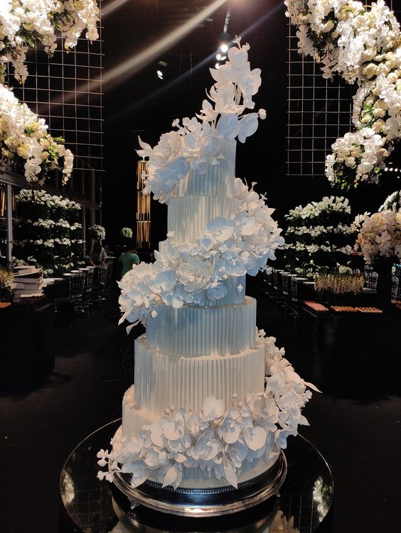 a beautiful textural white wedding cake with white sugar flower swirls around it is a very sophisticated and chic idea