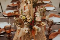17 a bold western wedding table setting with an orange runner and rust napkins and glasses, bold dried blooms and grasses