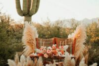 20 a bright western wedding sweetheart table styled with rust and blush blooms, pampas grass, pastel candles and woven chairs