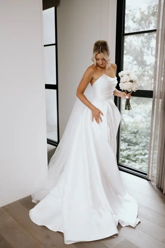a refined modern wedding ballgown with a draped bodice and multi-layered skirt with a train is a very chic idea