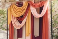 21 a modern colorful drape wedding backdrop with pampas grass and fronds is a bold idea for a modern boho wedding