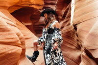 21 a super bold black and white western bridal look with a strapless printed wedding dress, a black leather corset, black cowboy boots and a black hat