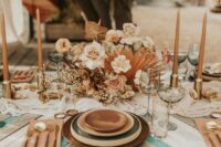 22 a chic wedding tablescape with layered plates, a lush blush and rust floral centerpiece, rust candles and rust napkins