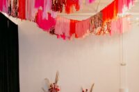 22 a colorful wedding ceremony space with bright streamers over the space and matching colorful blooms composing an altar