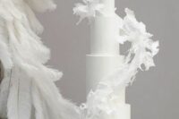 22 a tall white wedding cake with a white sugar swirl around it looks spectacular and refined adding interest to your wedding dessert station