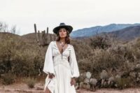 24 a western bridal outfit with a gorgeous boho lace wedding dress with a train, a black hat, tall black cowgirl boots and statement accessories