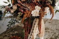 25 a western wedding bouquet of neutrla, burgundy and rust blooms, greenery and long lace ribbon is amazing for a western bride