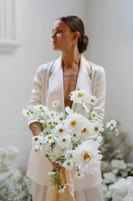 a modern white wedding bouquet with no greenery will match a modern or minimalist bridal look