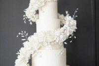 26 a white textural wedding cake with a swirl of white blooms and leaves is a very refined and chic idea for a modern formal wedding