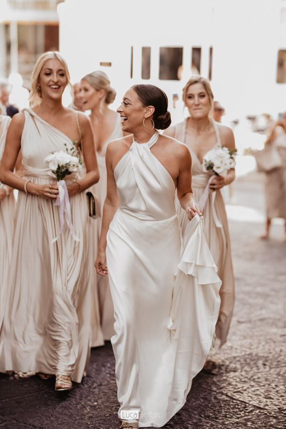 an effortlessly chic plain wedding dress with a halter neckline, a draped bodice and a skirt with a train is pure chic