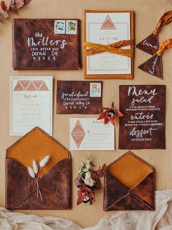 a western wedding invitation suite with brown leather envelopes, printed cards, mustard ribbon and calligraphy is wow