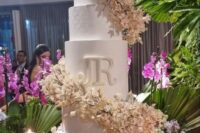 29 an oversized white textural wedding cake with super lush pink blooms swirling around the cake for a spectacular look