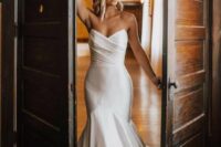 30 an exquisite modern strapless wedding dress with a mermaid silhouette, a draped bodice and a train is jaw-dropping