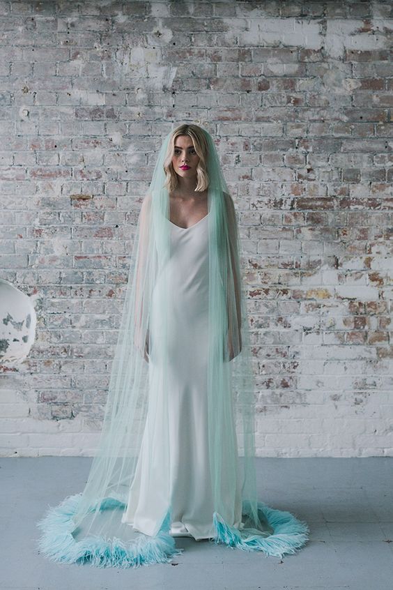 a mint blue bridal veil with feathers is a fantastic touch of color and a unique take on the traditional accessory