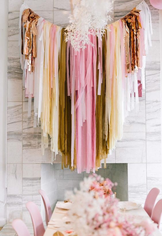 a lovely pink, white, gold and yellow streamer wedding backdrop can be hung anywhere you need it