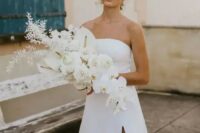 33 a lush white wedding bouquet with callas, orchids and some dried foliage, with a catchy shape and a cascading element is idea for a minimalist bride