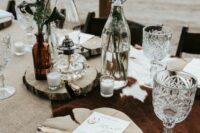 33 a western wedding tablescape with a burlap tablecloth, a cowhide piece, wood slice placemats and manues, bold and white blooms