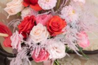 35 a bright modern wedding bouquet of peachy, pale pink and red roses, peony roses, red anthurium and mauve ribbons is amazing