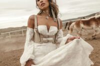 36 a western bridal look with a lace strapless wedding dress with puff sleeves, a grey leather corset, grey boots and statement jewelry