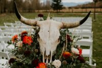 36 boho western wedding cermeony space with greeneyr, neutral and red blooms and a large skull on top is a lovely idea for a western wedding