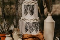 38 a boho western wedding cake in black and white, with texture and black pattern, with dried branches and cacti around