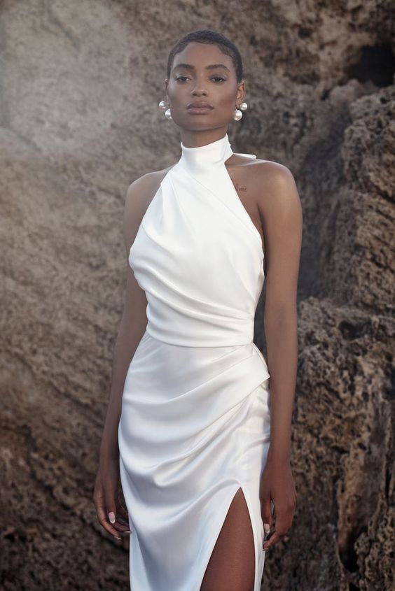 a modern hatler turtleneck wedding dress with a draped bodice and skirt plus a thigh high slit is a chic idea