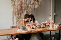 40 a super fun disco-inspired wedding reception space with silver disco balls, blooms and silver tinsel fringe over the table