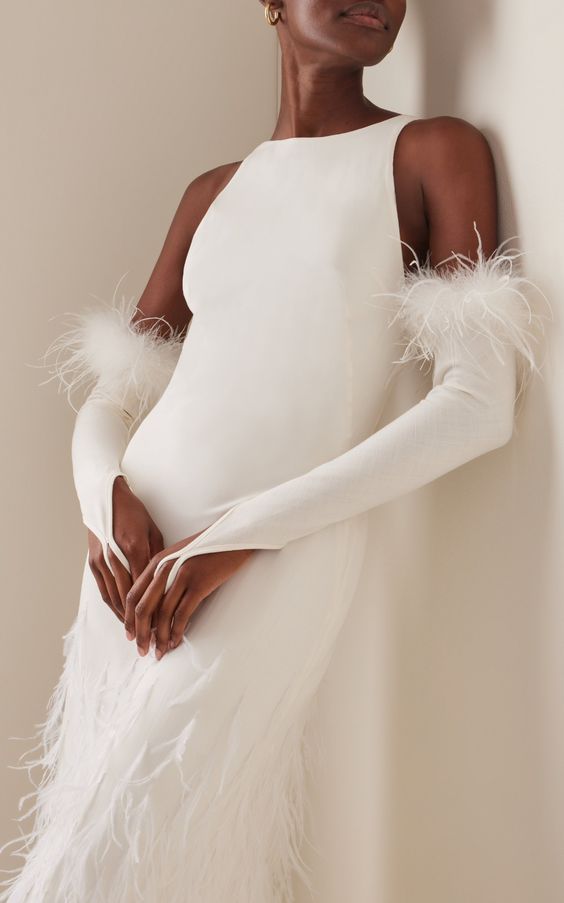 long feather embellished wedding gloves paired with a plain feathered wedding dress will give an edge to your look