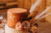 44 a rust and white wedding cake with gold leaf, macrame, neutral blooms, pampas grass and leaves is a cool idea for a western wedding
