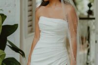 44 a strapless fully draped wedding dress with a thigh high slit and a pearl veila re a lovely and bold combo for a wedding