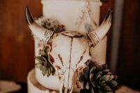 46 a white wedding cake with succulents and cacti on top, with a skull is a lovely idea for a boho or western wedding