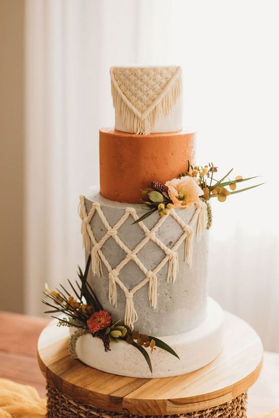 a white, rust and grey wedding cake with wite sugar macrame, fresh and dried blooms and greenery is amazing for a western wedding