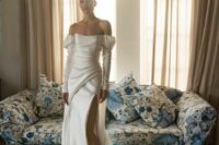 50 an off the shoulder wedding dress with puff sleeves, a draped bodice and a skirt, a thigh high slit and a train is dramatic