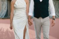 51 an ultra-modern plain halter neckline wedding dress with a draped bodice and skirt plus a thigh high slit and white shoes