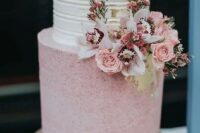a beautiful and chic wedding cake with a white striped tier, a pink polka dot one, pink and white blooms and greenery is wow
