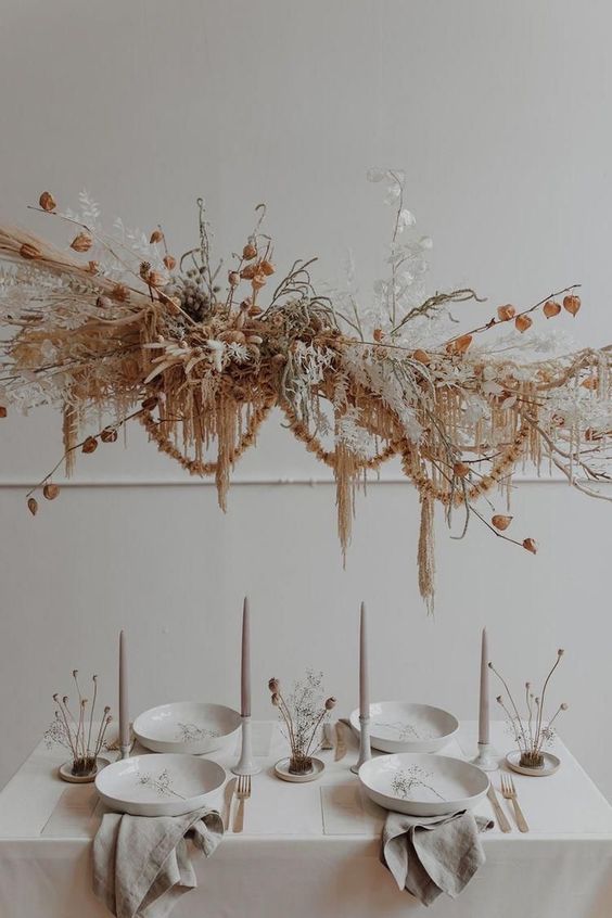 a beautiful dried grass and bloom wedding installation with dried grasses, lunaria, pampas grass, branches and some seed pods, also dried