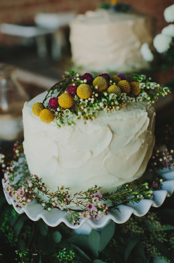 a beautiful summer wedding cake topped with billy balls, waxflowers and some bright allium is ideal for a wildflower wedding