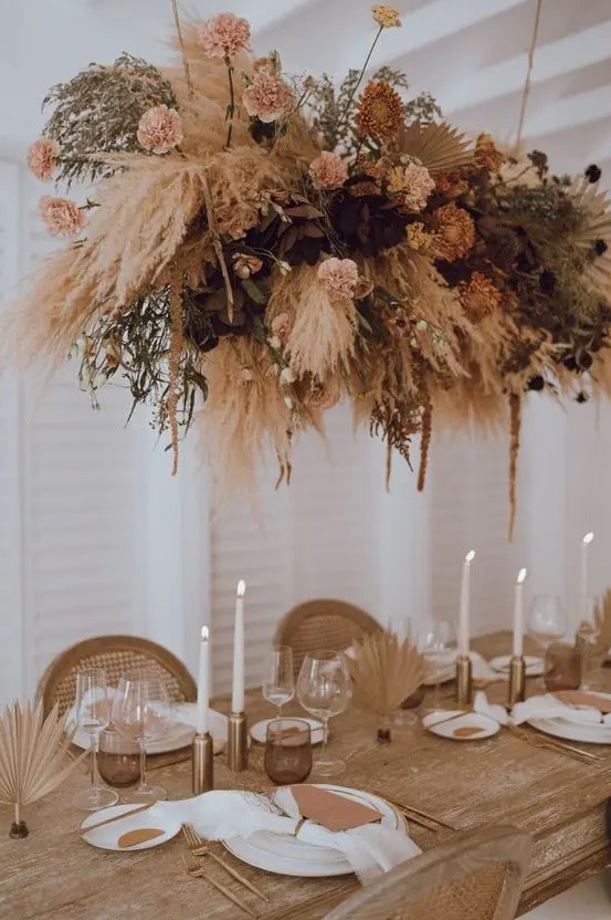 a beautiful wedding overhead installation of blush and dried blooms, pampas and other grasses and fronds is chic