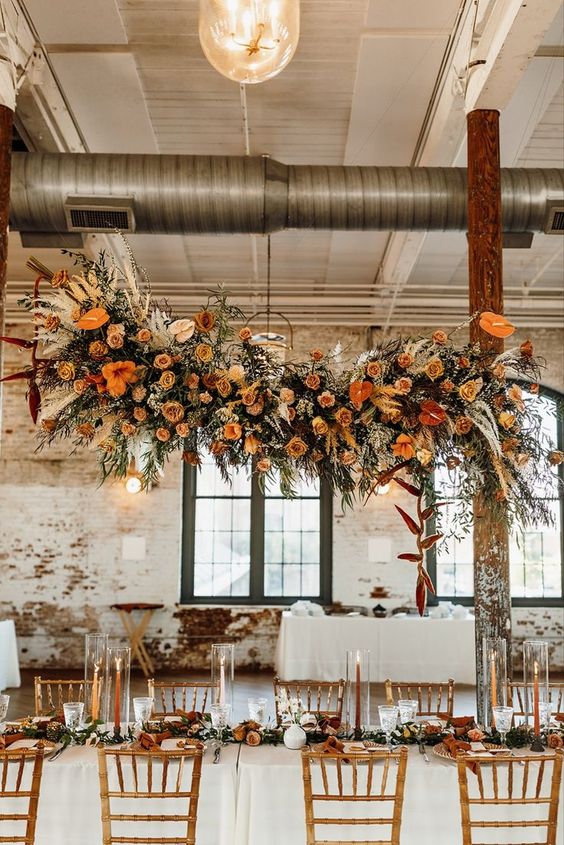 a bold and catchy orange, yellow and pink floral wedding installation spruced up with greeneyr and pampas grass is amazing