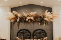 a bold dried flower wedding installation with pampas grass, greenery and some bold fronds is a catchy idea for a boho wedding
