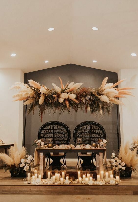 a bold dried flower wedding installation with pampas grass, greenery and some bold fronds is a catchy idea for a boho wedding