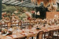 a bold pampas grass and fronds is a cool addition to the reception decor, great for a boho tropical wedding