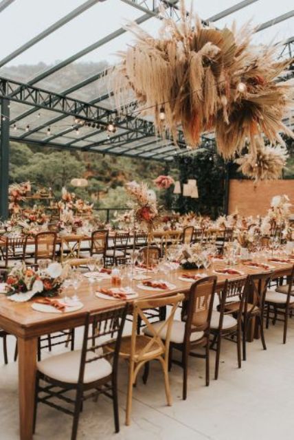 a bold pampas grass and fronds is a cool addition to the reception decor, great for a boho tropical wedding